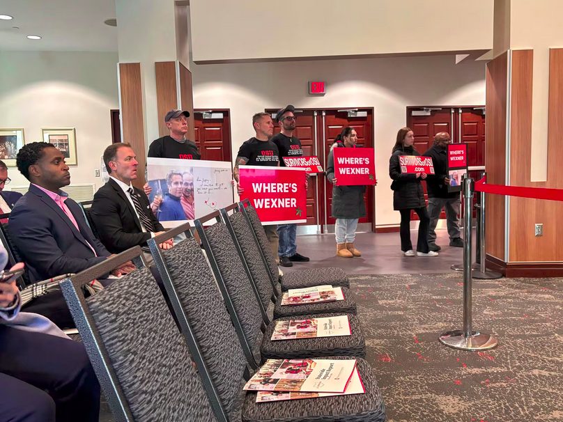 Protesters hold signs at the Ohio State University board of trustees meeting today in Columbus, Ohio. Photo taken by Michael DiSabato